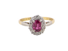 A traditional cluster ring. Features to the centre a dark pink red ruby, oval cut 6x4mm (0.50 carats)