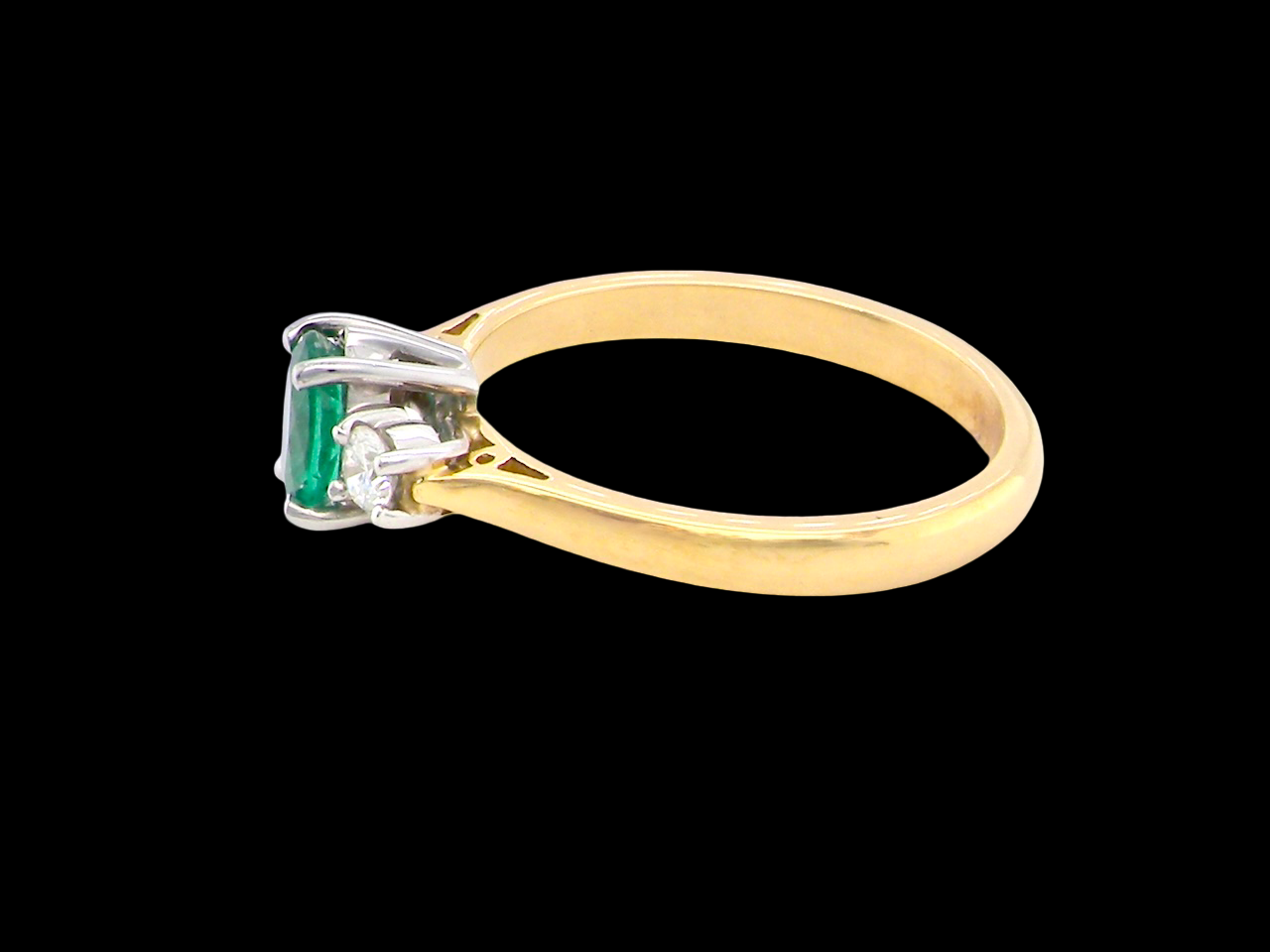 A traditional three stone Emerald and Diamond ring