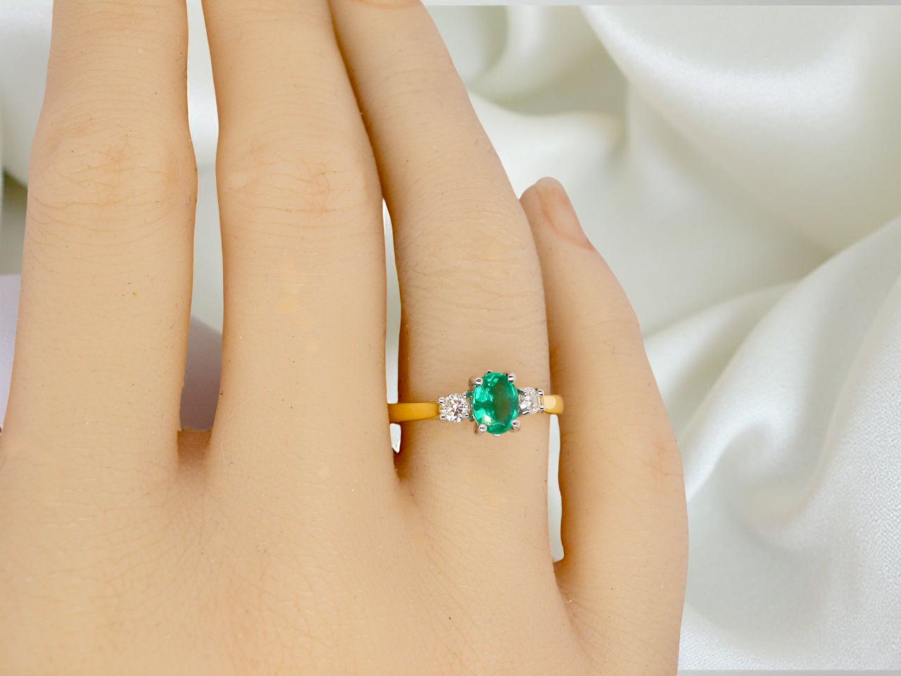 A traditional three stone Emerald and Diamond ring