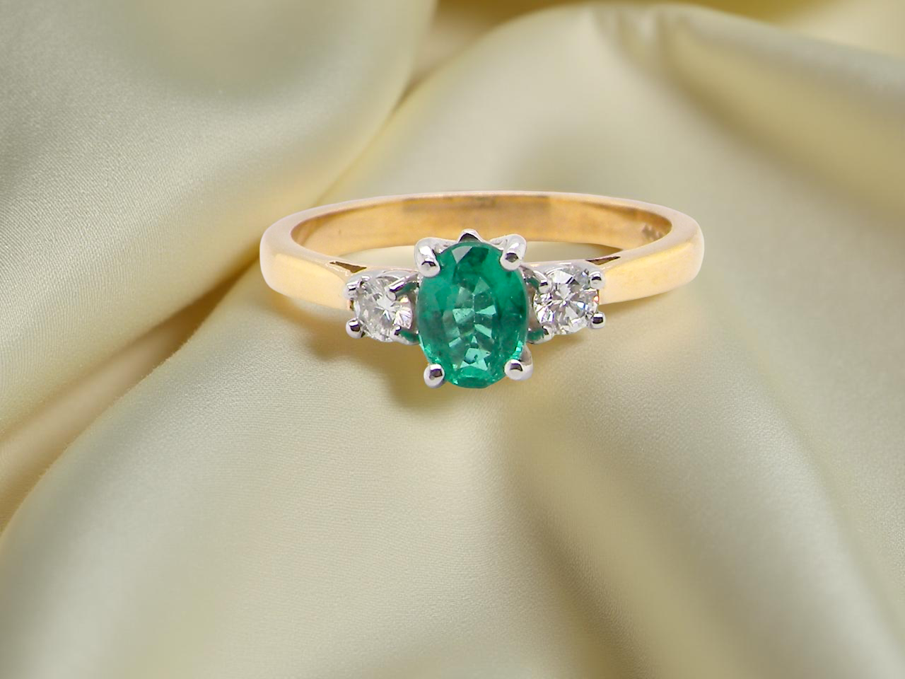 A traditional three stone Emerald and Diamond ring