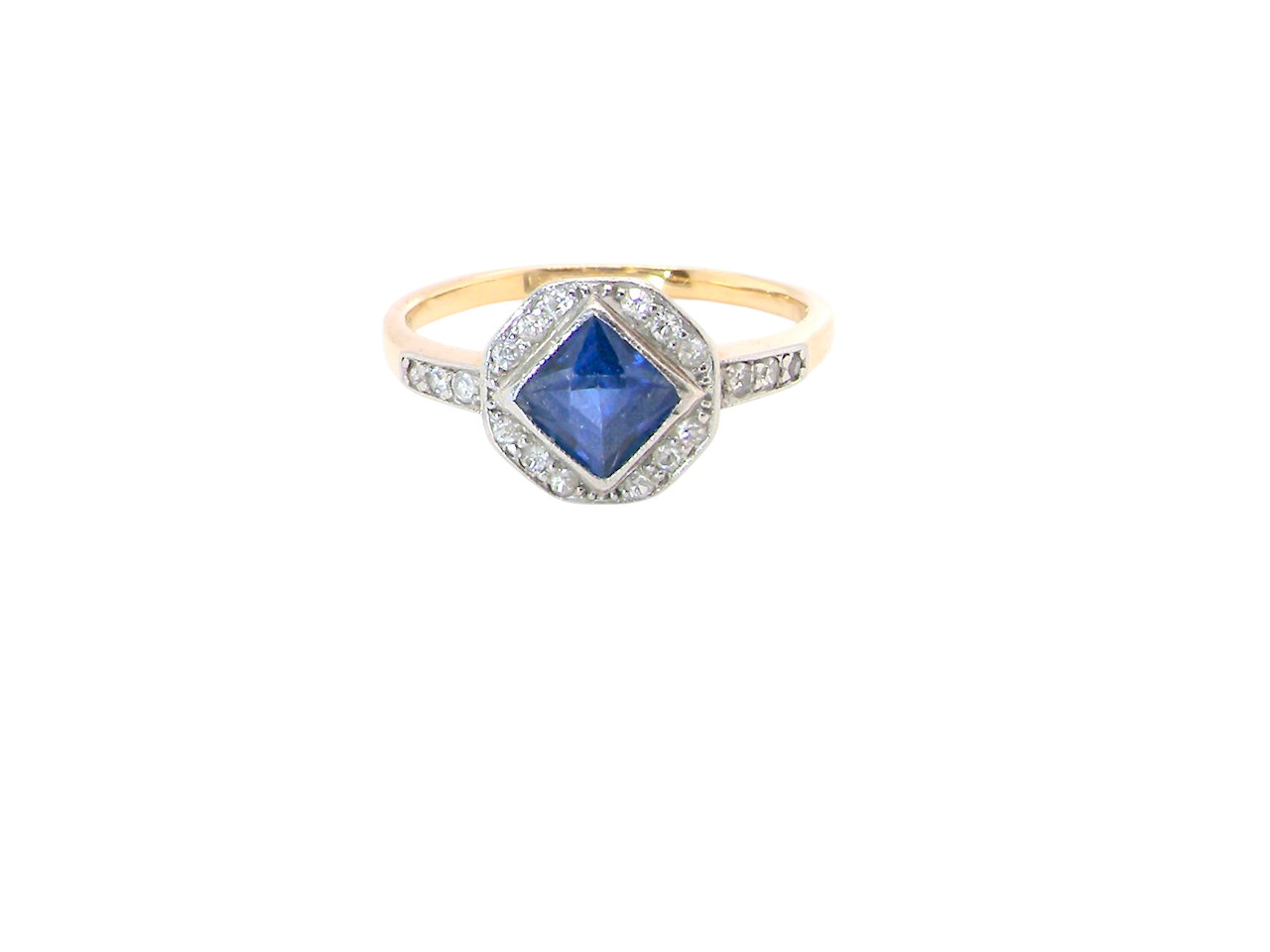 A very pretty Art Deco cluster ring. To the centre a mid to dark blue sapphire, square cut but set as a 'diamond shape'. Measures 5x5mm, rim setting.