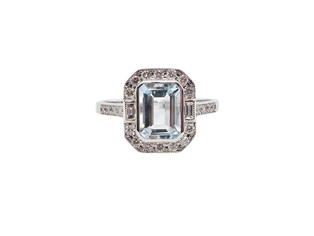 A very pretty cluster ring. Features a step cut aquamarine centre stone, 8x7mm (est 1.21 carats). Plain rim setting.