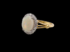 A vintage cluster ring. Features an oval white opal, measures 10x8mm, with a good play of colour. side
