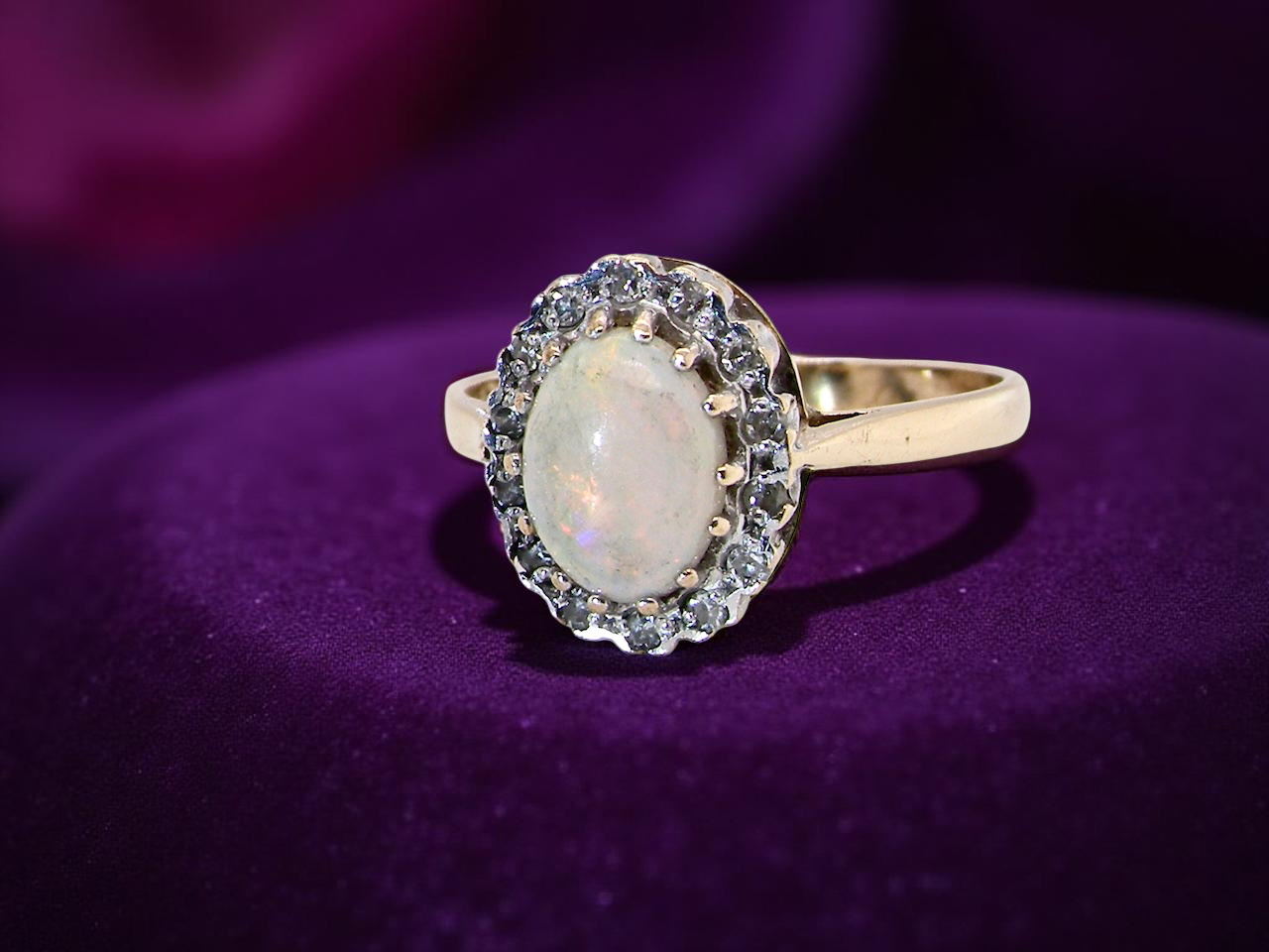 A vintage cluster ring set with an oval cabouchon cut opal A