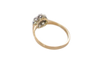 A yellow gold ring with a cluster of small clear gemstones at the top, shown on a plain white background.