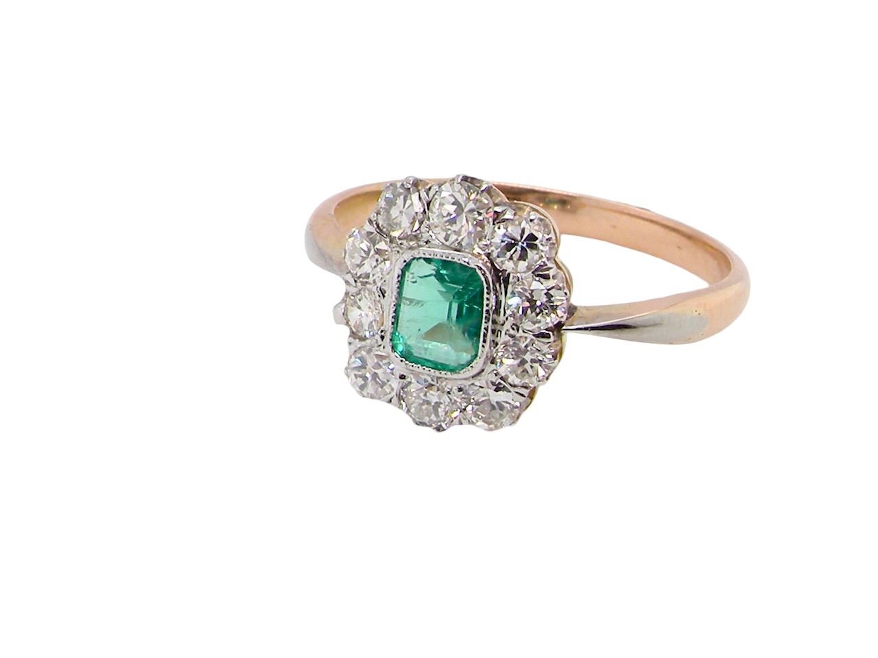 A vintage cluster ring, the centre stone a cushion shaped emerald 4x3.5mm, Mille grain setting.
