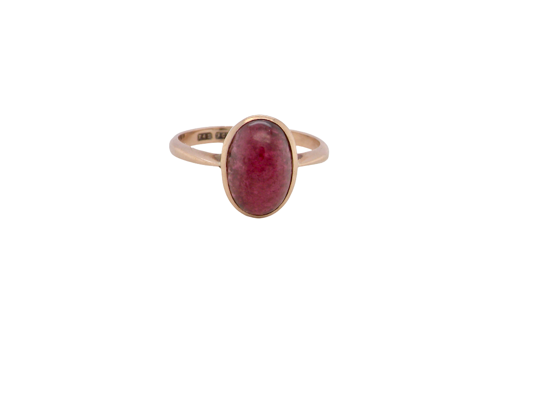A vintage dress ring. Set with an oval cabouchon cut garnet, 11x7mm, in a rim style setting.