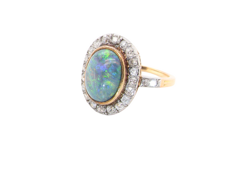 A vintage early 20th century cluster ring. Features to the centre a black opal doublet, 