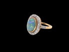 A vintage early 20th century cluster ring. Features to the centre a black opal doublet, with an excellent play of colour, measures 9.5x7.5mm, in a rim setting.
side