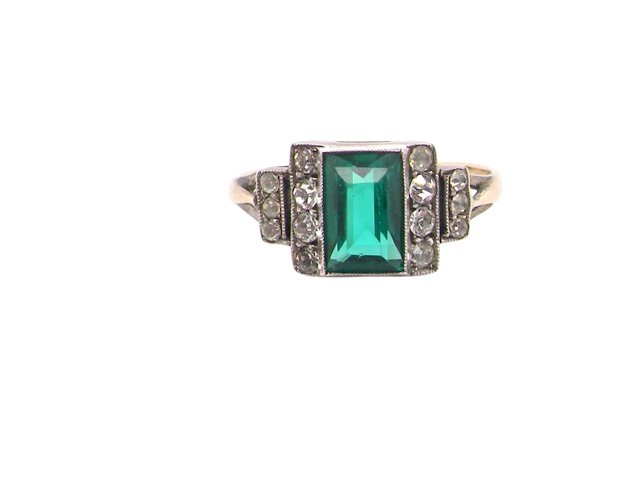 A vintage early 20th century dress ring. The centre stone a vibrant crystal clear green paste stone, 8x6mm.