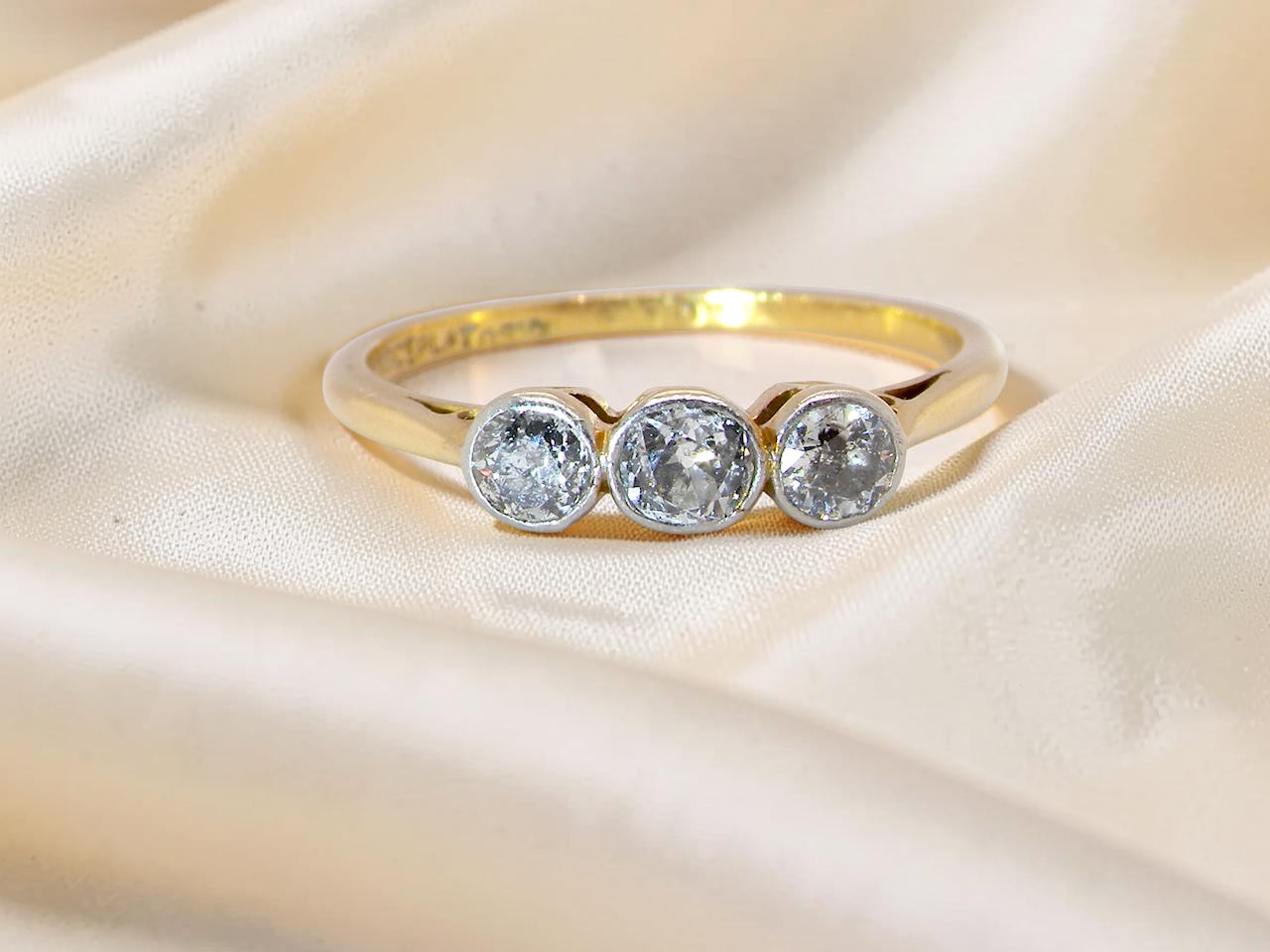 A vintage early 20th century trilogy ring. Set with old cut diamonds, centre stone 3.8mm, and each side a 3.6mm diamond (total carat weight estimated at 0.55 carats)
