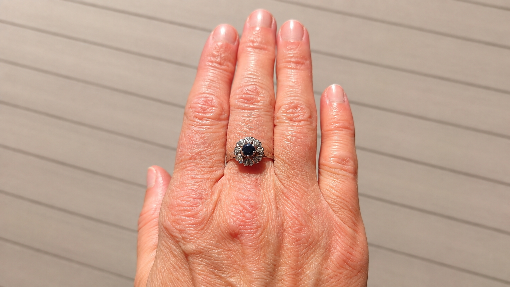 A vintage sapphire cluster ring on a hand