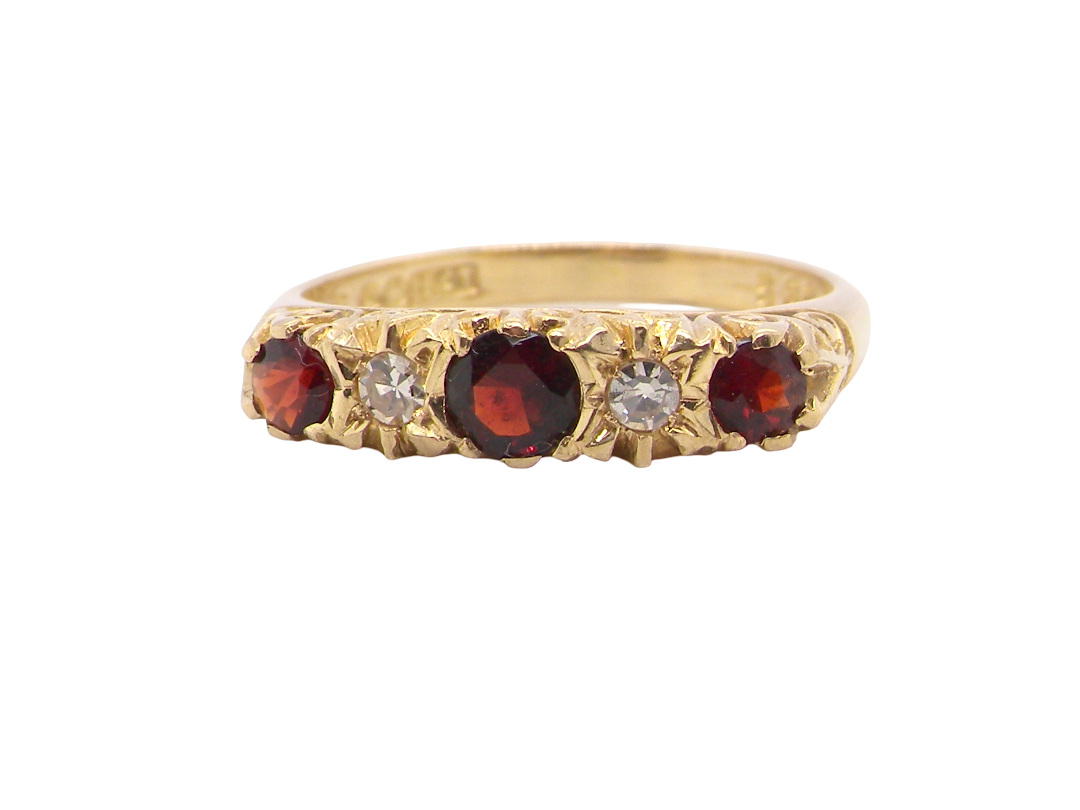 A vintage style 18 carat gold boat shaped ring. Features three dark red garnets, centre 4mm, each end a 3mm stone
