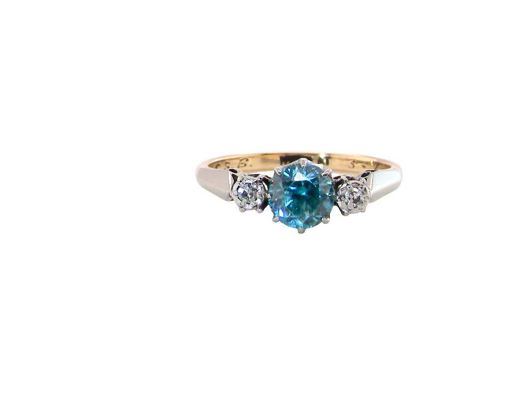 A vintage three stone ring. Features to the centre a 6mm natural blue zircon, 6mm diameter, claw set.