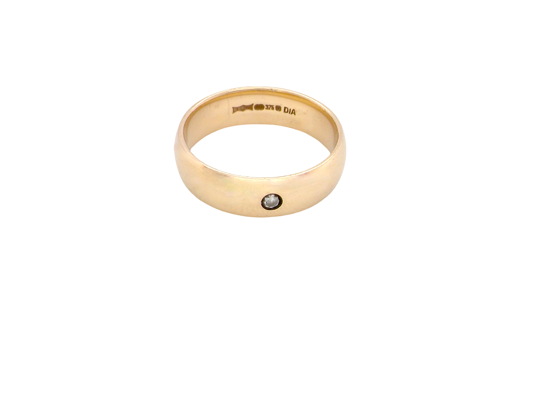 A wide 9 carat gold wedding ring. Set with a small diamond