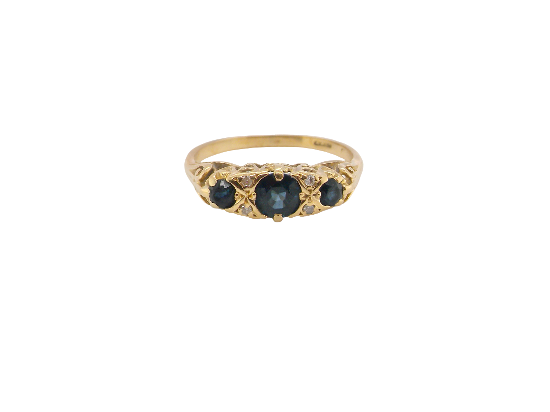 An 18 carat* boat shaped ring. Features three dark inky blue sapphires, centre 4.7mm, each end a 3mm stone.