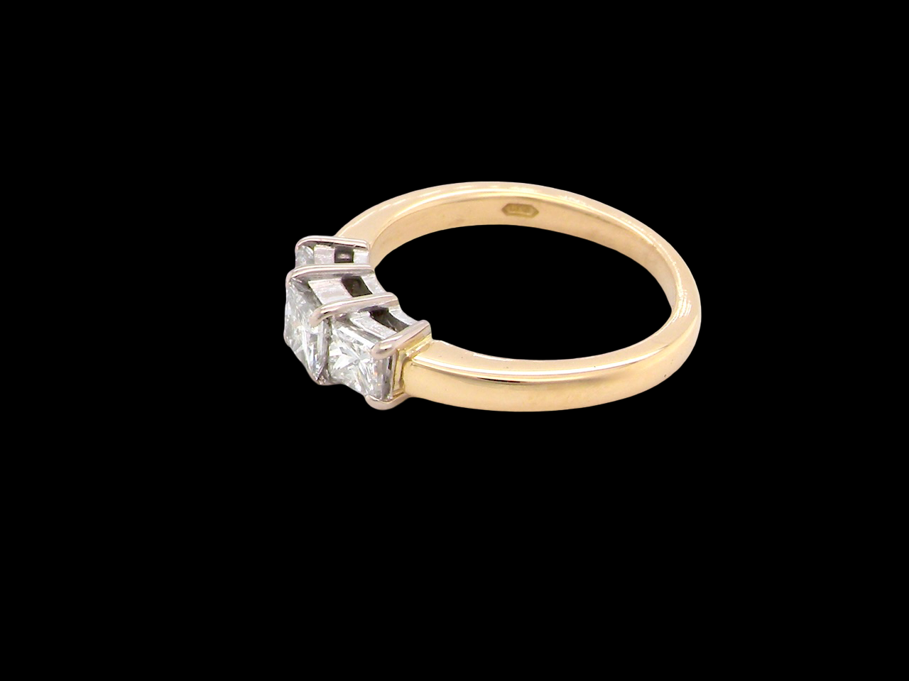 Gold ring with a diamond on a black background