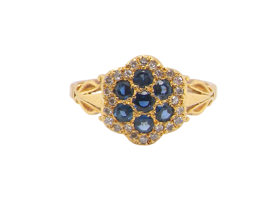 An 18 carat gold cluster ring.&nbsp; The centre a floral combination of seven sapphires, 