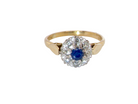 An 18 carat gold cluster ring, features to the centre a dark blue sapphire,. Claw set.