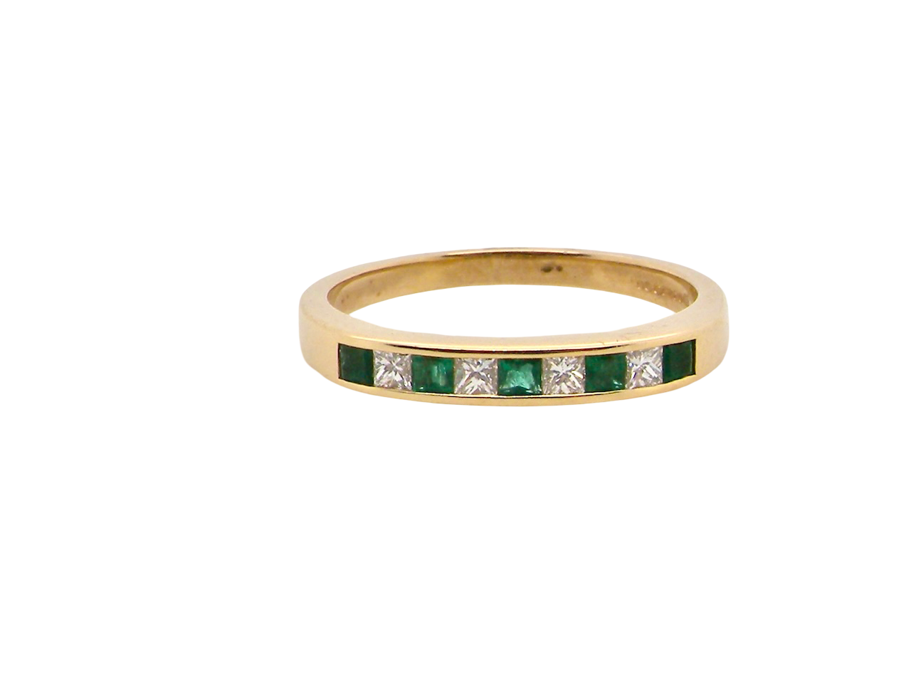 Gold ring with emeralds and diamonds on a white background