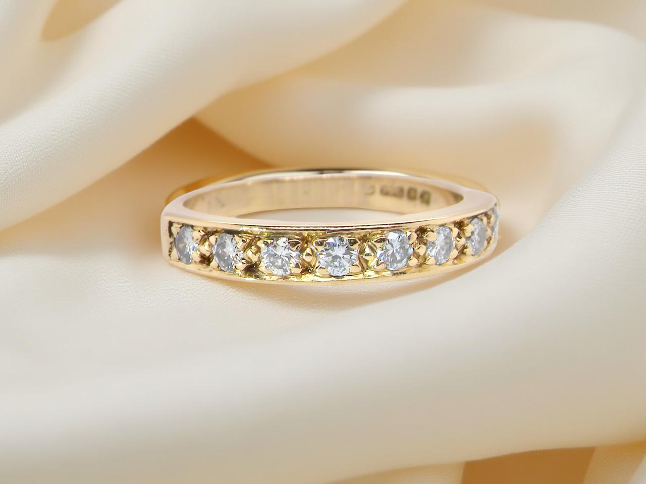 An 18 carat gold half-hoop eternity ring, set with eight  white diamonds