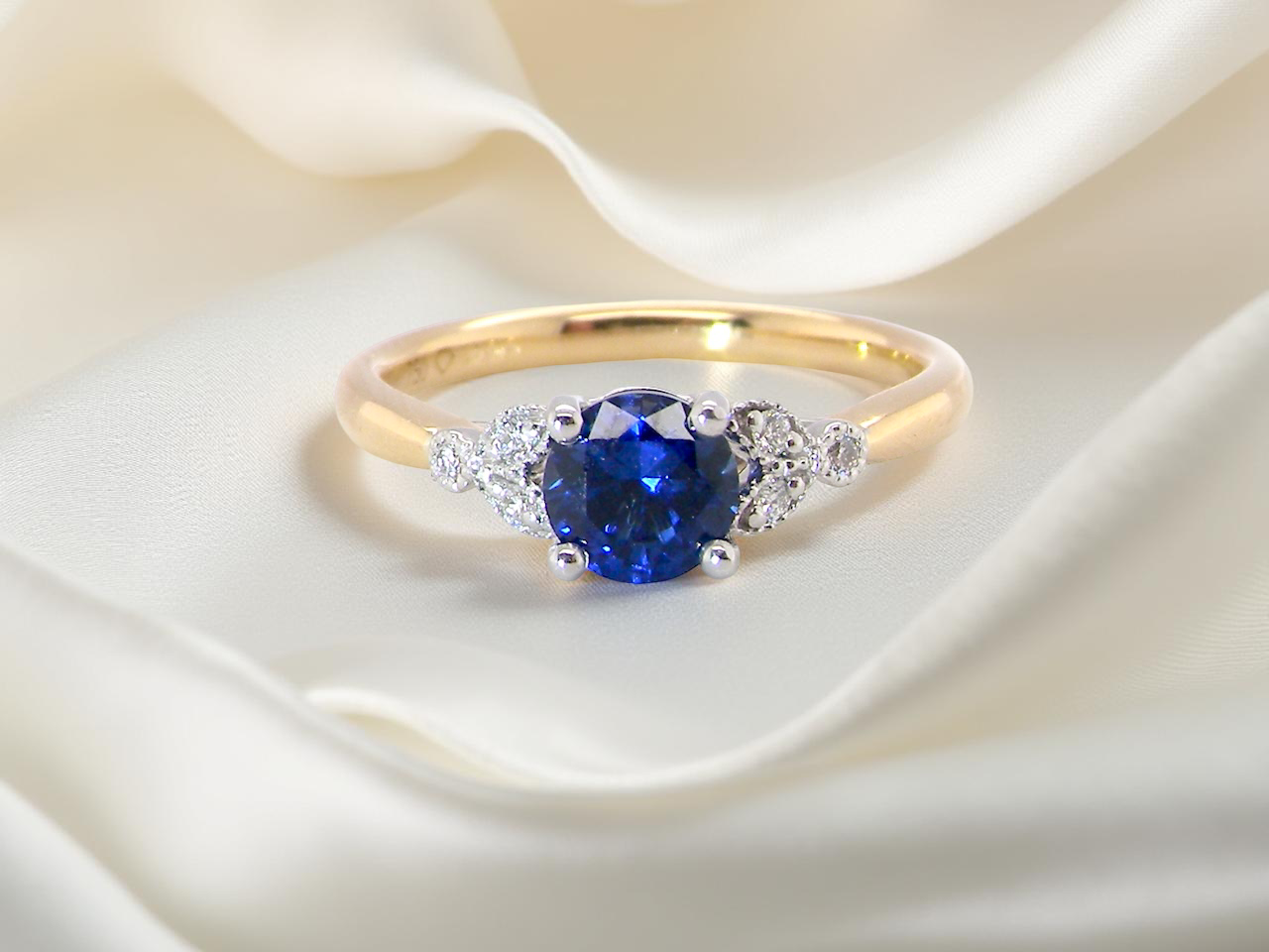 An 18 carat gold ring set with a vibrant blue sapphire, A