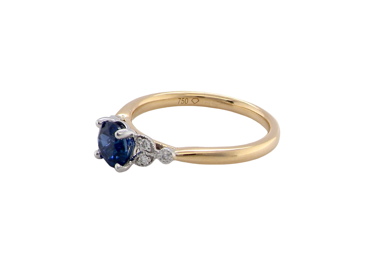 An 18 carat gold ring set with a vibrant blue sapphire,  side