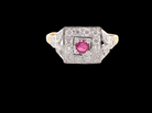 An 18 carat gold square cluster that features to the centre a round ruby and an outer halo diamonds.

