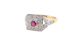 side view An 18 carat gold square cluster that features to the centre a round ruby and an outer halo of brilliant cut white diamonds.
