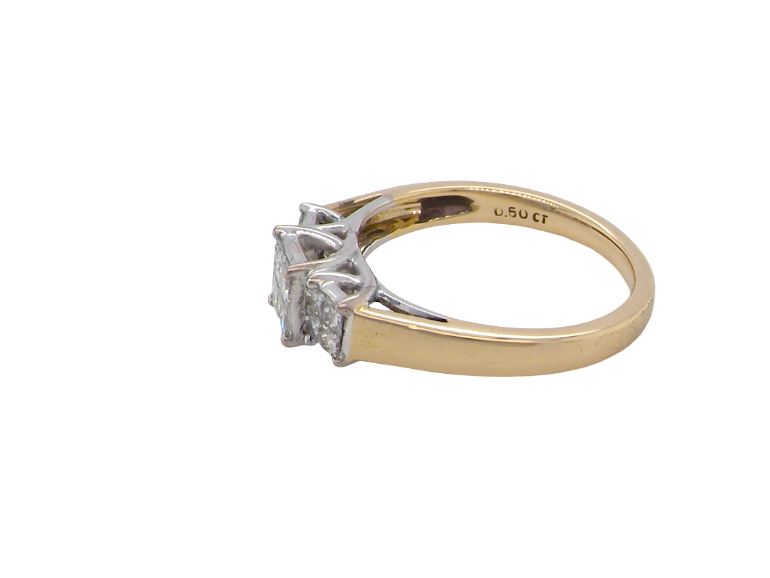 A two-tone diamond ring with a yellow gold band and a silver-colored setting featuring three marquise-cut diamonds, shown on a plain white background.