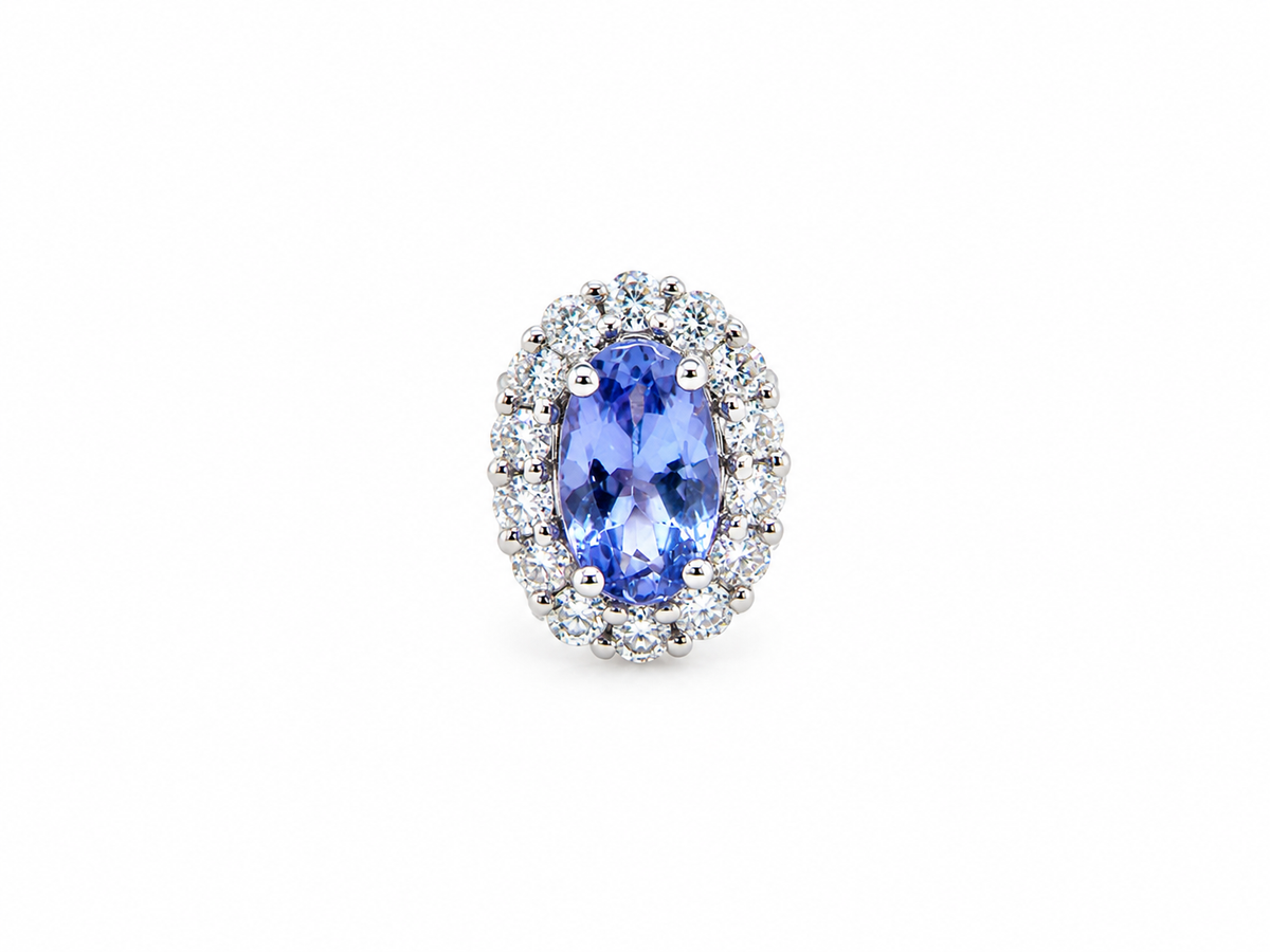 An oval halo ring featuring a central blue tanzite gemstone surrounded by a double halo of small clear round diamonds in a silver-colored setting, isolated on a white background.