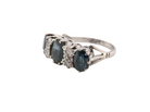An 18 carat white gold * dress ring. Features three large sapphires, centre 8x6mm (est 1.25 carats) and each side a 7x5mm sapphire (est 0.75 carats), dark blue hues, side on