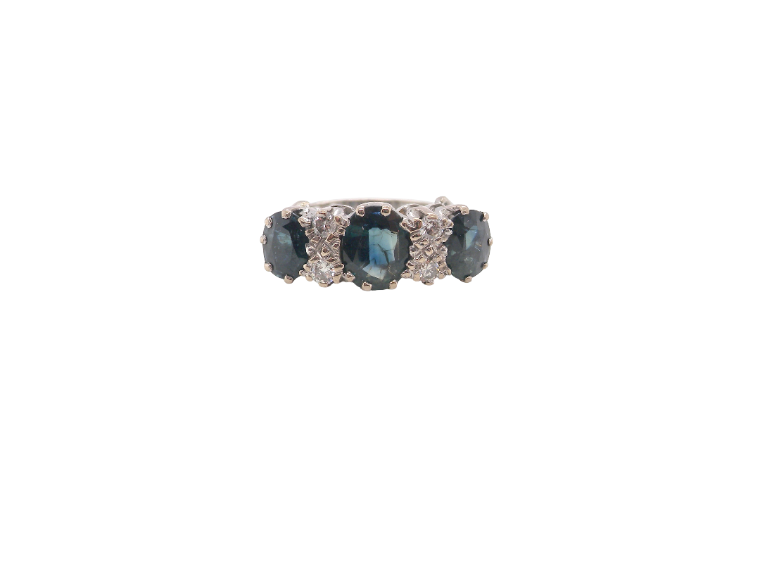 An 18 carat white gold * dress ring. Features three large sapphires, centre 8x6mm (est 1.25 carats) and each side a 7x5mm sapphire (est 0.75 carats), dark blue hues, with slight green tinges to edges.
