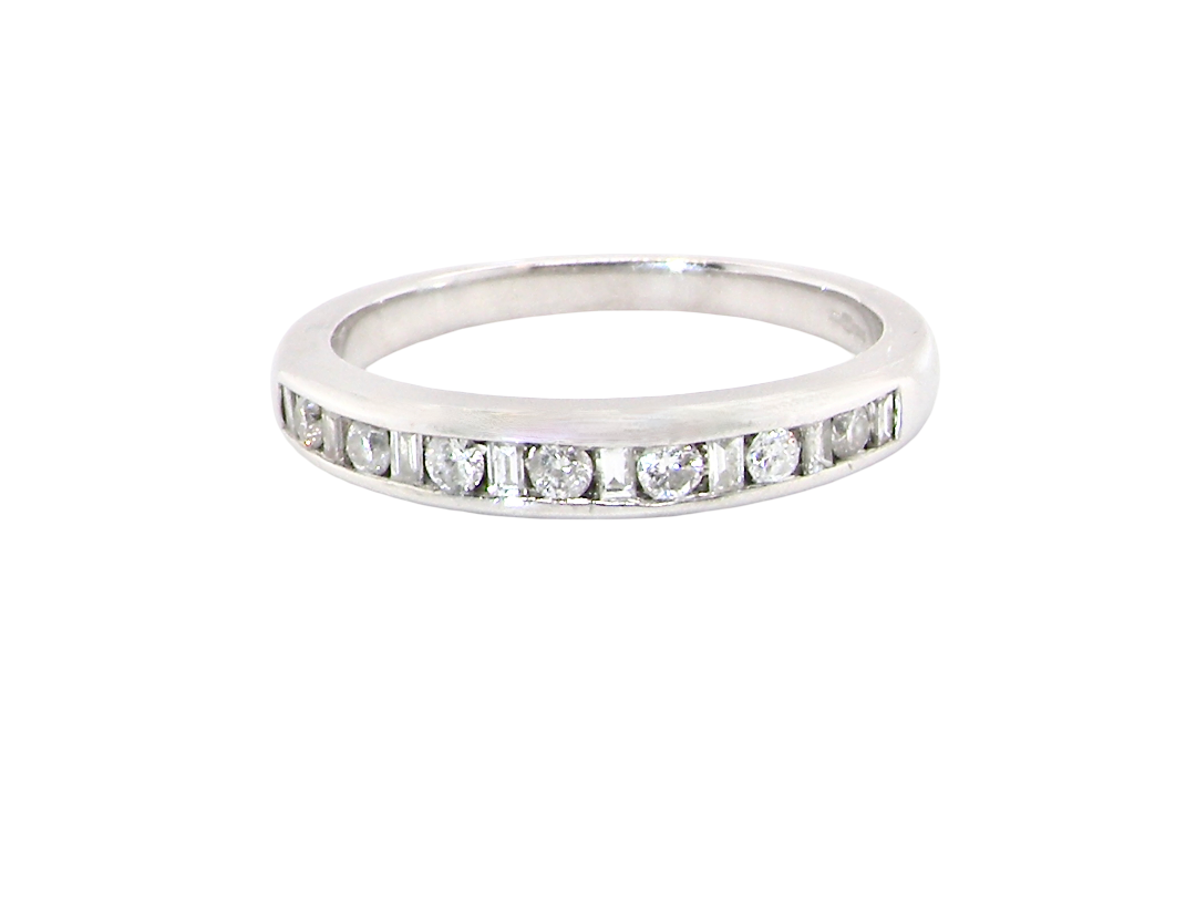 An 18 carat white gold half hoop eternity ring. Mixed cuts of white diamonds which consist of seven round brilliant stones, each 2mm diameter and eight baguette cut stones, each 2x1.5mm. 