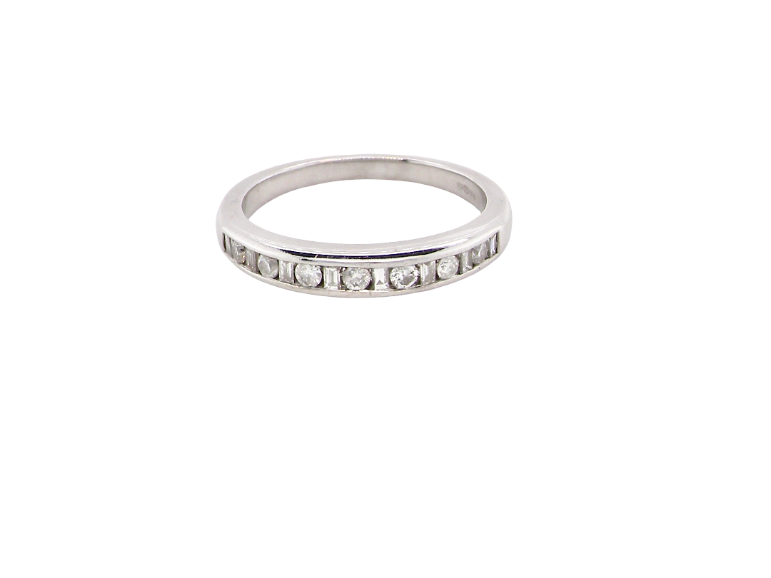 An 18 carat white gold half hoop eternity ring. Mixed cuts of white diamonds which consist of seven round brilliant stones, each 2mm diameter and eight baguette cut stones, each 2x1.5mm. Estimated total 0.50 carats.