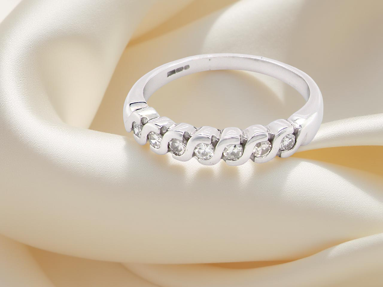 An 18 carat white gold half hoop eternity ring. Set with 7 brilliant cut white diamonds,