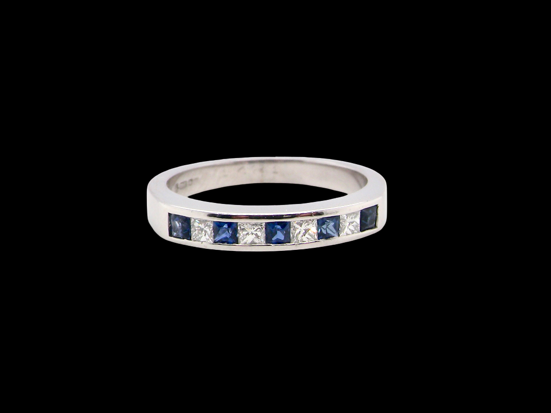 An 18 carat white gold half hoop eternity ring. Set with princess cut white diamonds, total of four- estimated 0.40 carats (2.4mm each) 