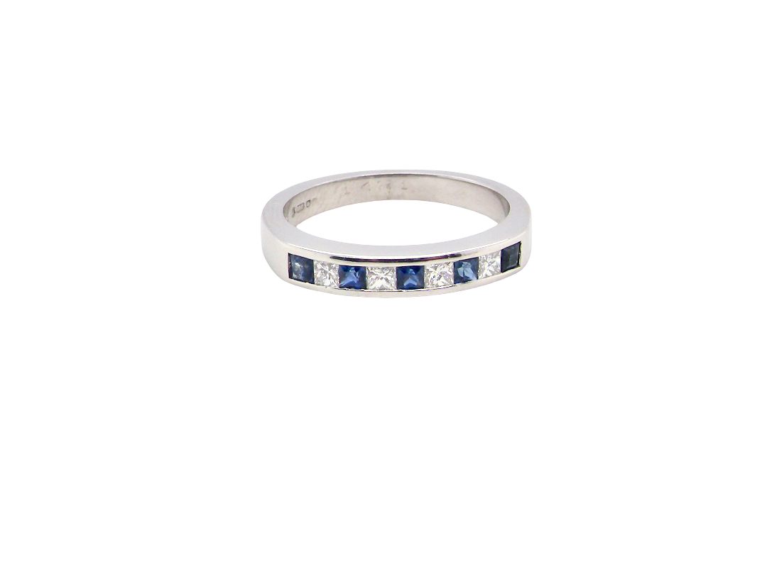 An 18 carat white gold half hoop eternity ring. Set with princess cut white diamonds, total of four- estimated 0.40 carats (2.4mm each) colour H-j, clarity Si.