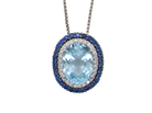 An oval pendant necklace featuring a large light blue topaz center stone, surrounded by a halo of small white stones and a border of deep blue sapphires, suspended on a silver-toned chain against a plain white background.