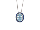 An oval pendant necklace featuring a light blue topaz center stone surrounded by a halo of silver-toned pavé diamonds and a border of deep blue sapphires, suspended from a silver-toned chain on a white background.