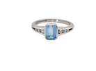 An 18 carat white gold ring, features a rectangular step cut aquamarine, measures 7x5mm (st one carat) sky blue, fine clarity. Rim setting.