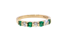 An 18 carat yellow gold half hoop eternity ring. Set with four bright green emeralds, each 3mm diameter .