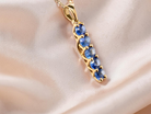 An 18 carat yellow gold pendant. This features five oval cut sapphires, each 5x3.5mm.&nbsp;

