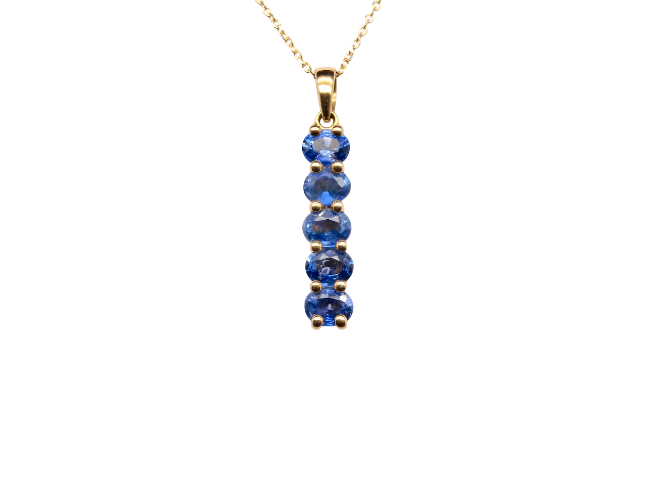 An 18 carat yellow gold pendant. This features five oval cut mid cornflower blue sapphires, 
