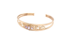 Gold bracelet with decorative elements and small stones on a white background