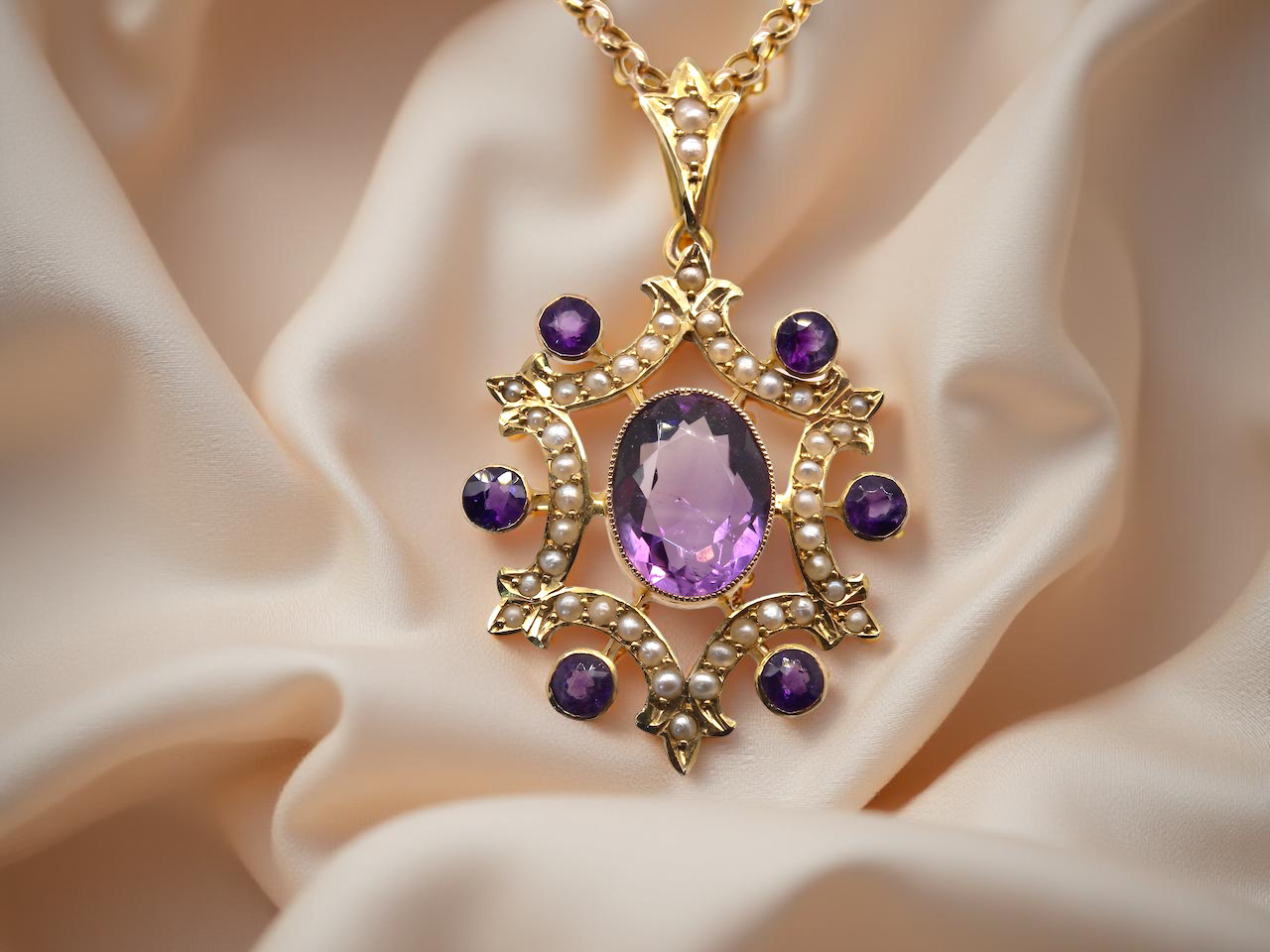 Gold pendant with purple gemstone on a beige fabric background