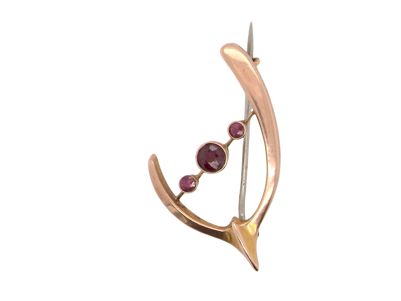Gold brooch with embedded gemstones on a white background