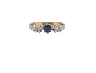 An early 20th century engagement ring. The centre stone a dark blue sapphire