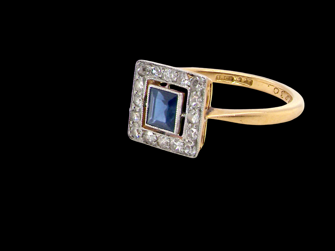An early 20th century square cluster ring. Features a square inky black blue sapphire, 4x4mm (est 0.25 carats) mille grain set.side