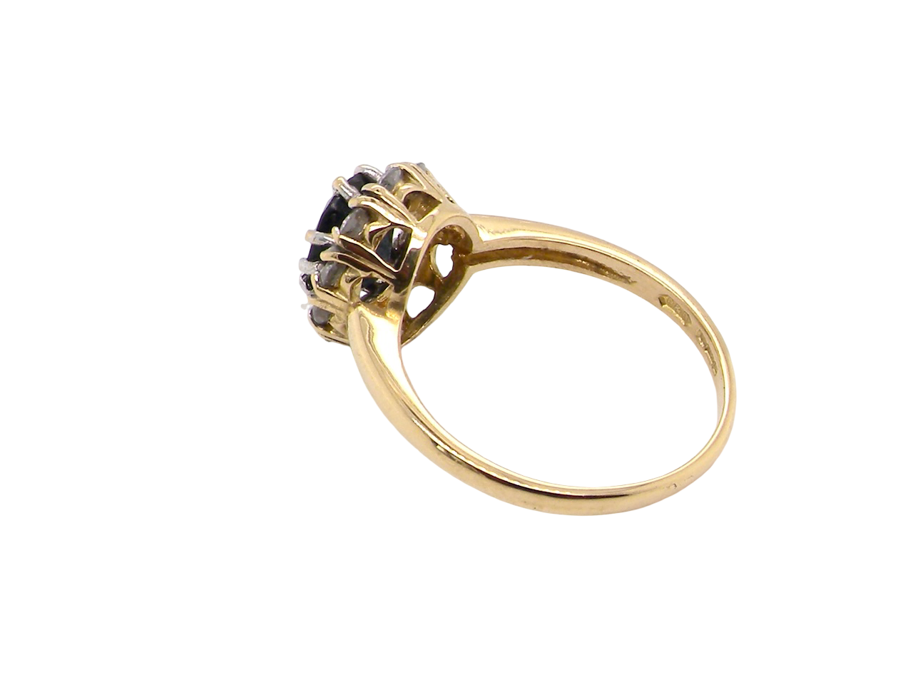 side An elegant 18 carat gold cluster ring featuring a striking inky dark blue sapphire at its centre. 